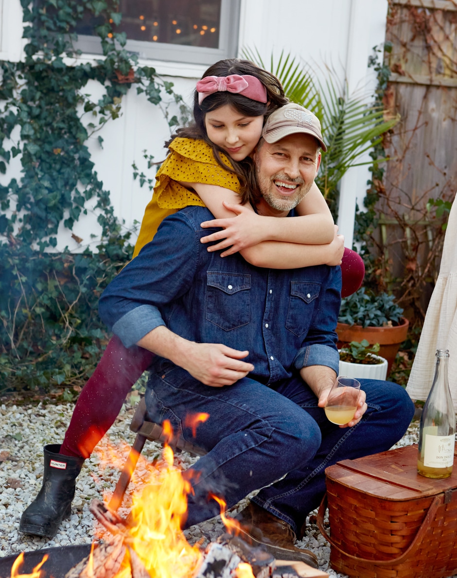 Andras and daughter hugging by fire pit