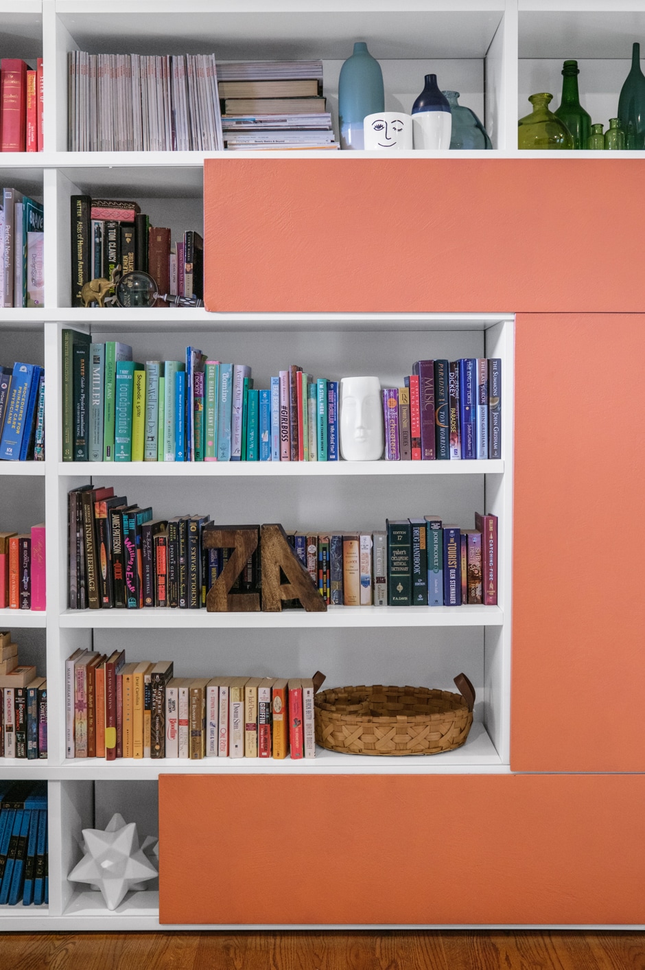 book shelf organized by color with sliding doors