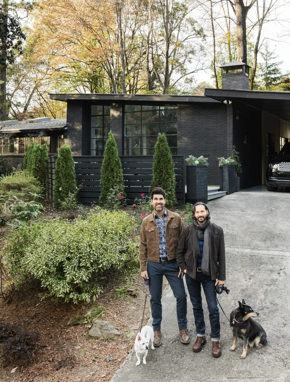 Brian and Hollis with dogs standing in front of mid-century modern house