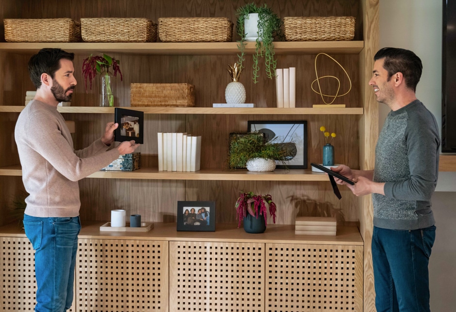 brothers holding picture frames in front of custom built in cabinet