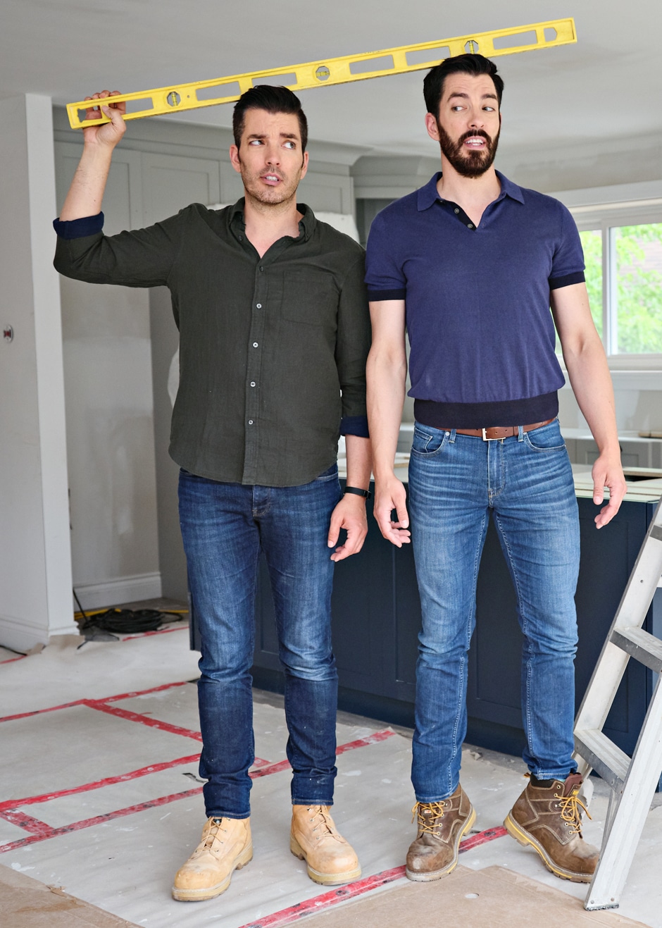 brothers standing by each other measuring their height with a level