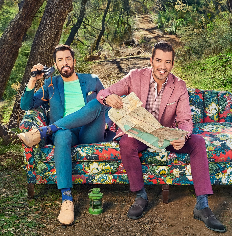 Drew and Jonathan sitting on colorful reupholstered couch in the forest