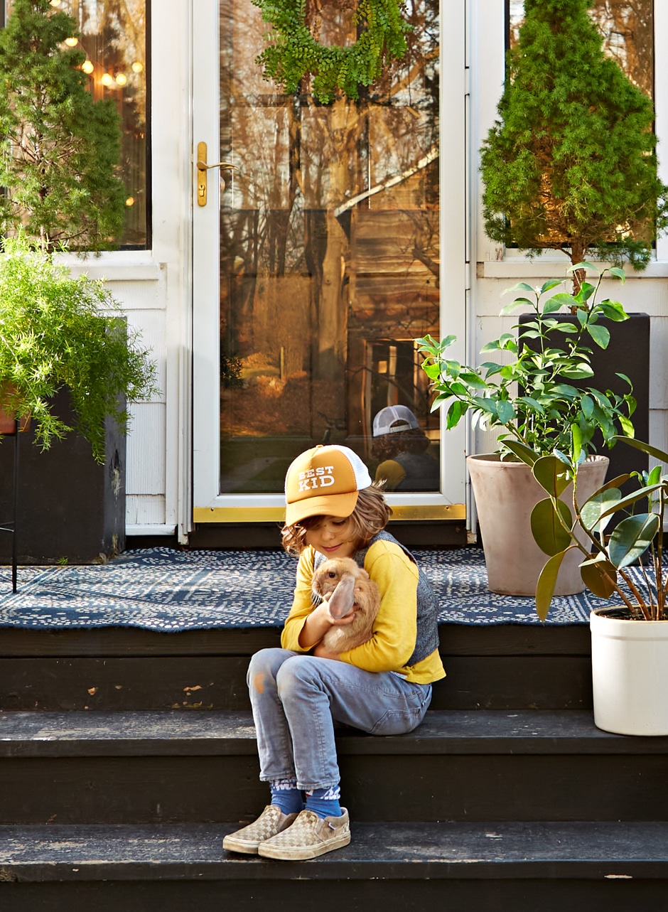 Matyas sitting on steps holding pet bunny