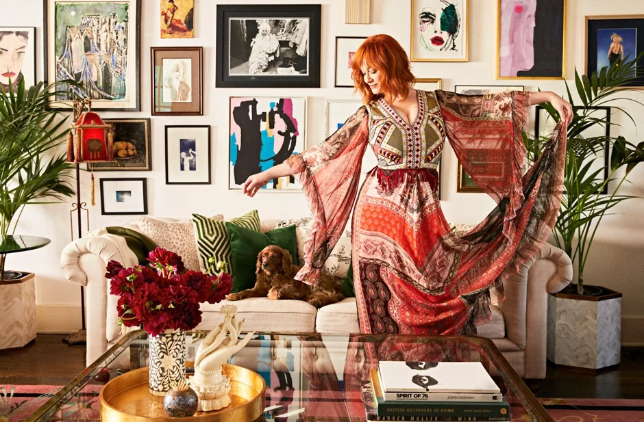 Hendricks in bohemian dress standing in eclectic living room