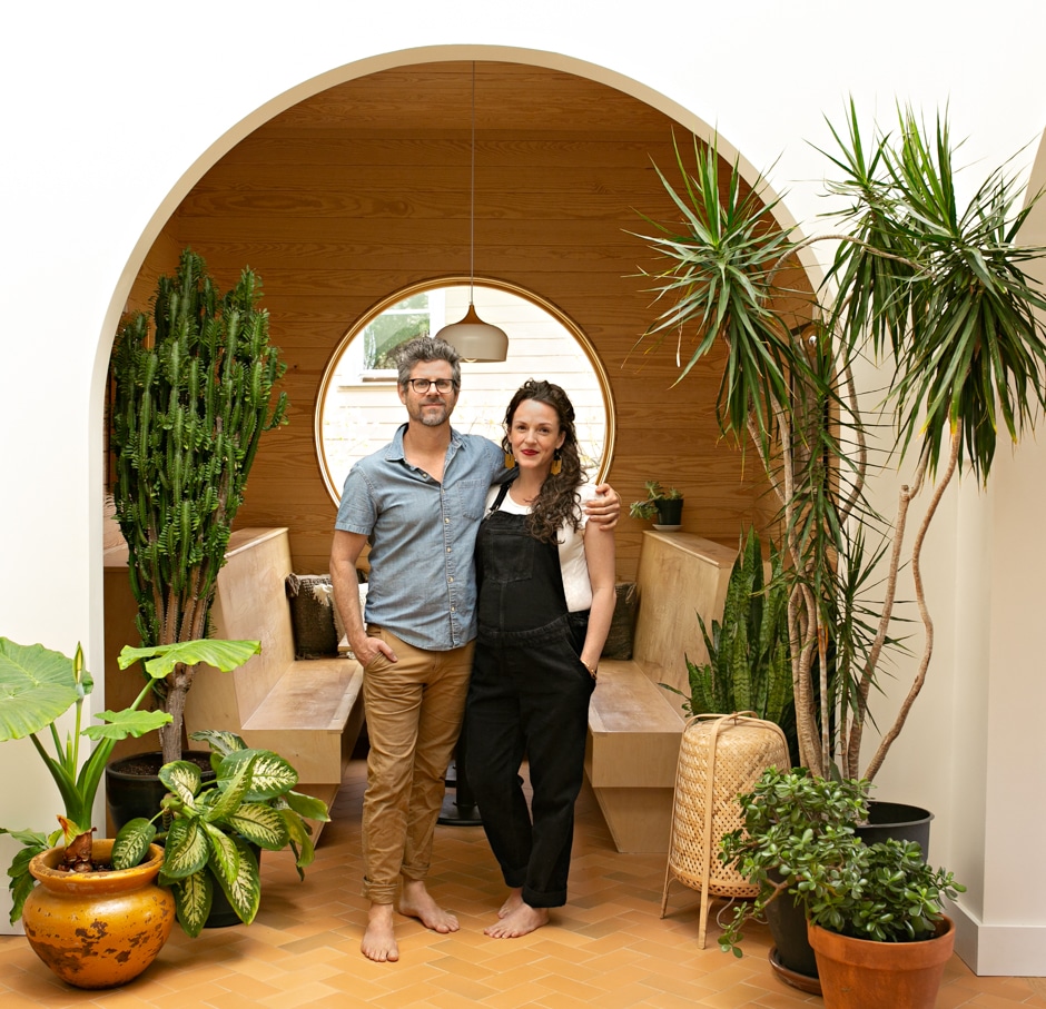 couple standing on arched entryway surrounded by plants