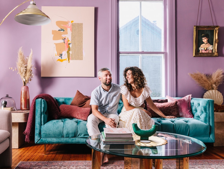 couple sitting on couch in purple living room