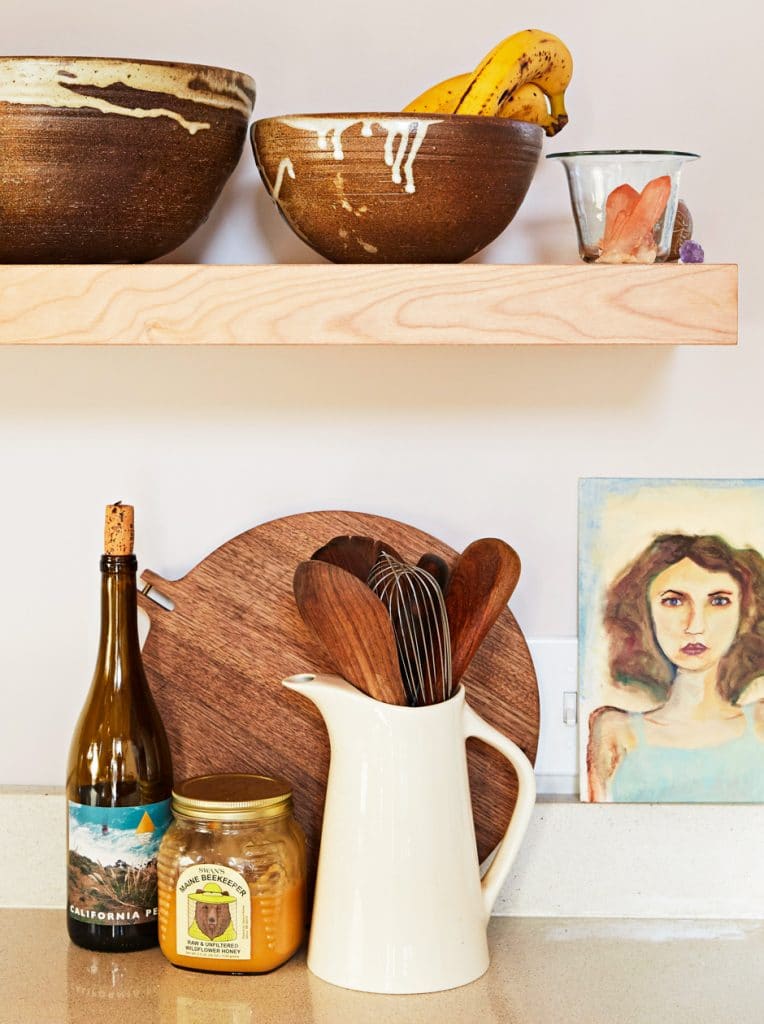 kitchen counter top cutting board, utensils, and bottles