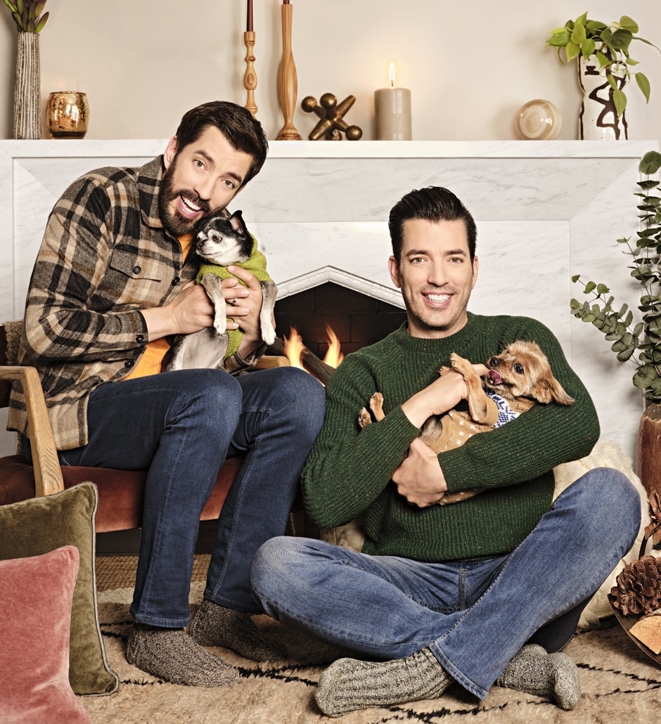 Drew and Jonathan cuddling dogs by the fire