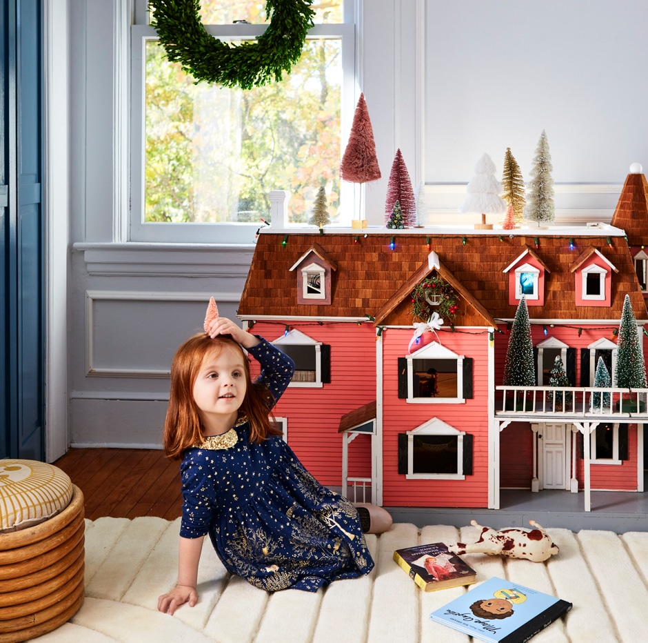 girl playing with festive dollhouse