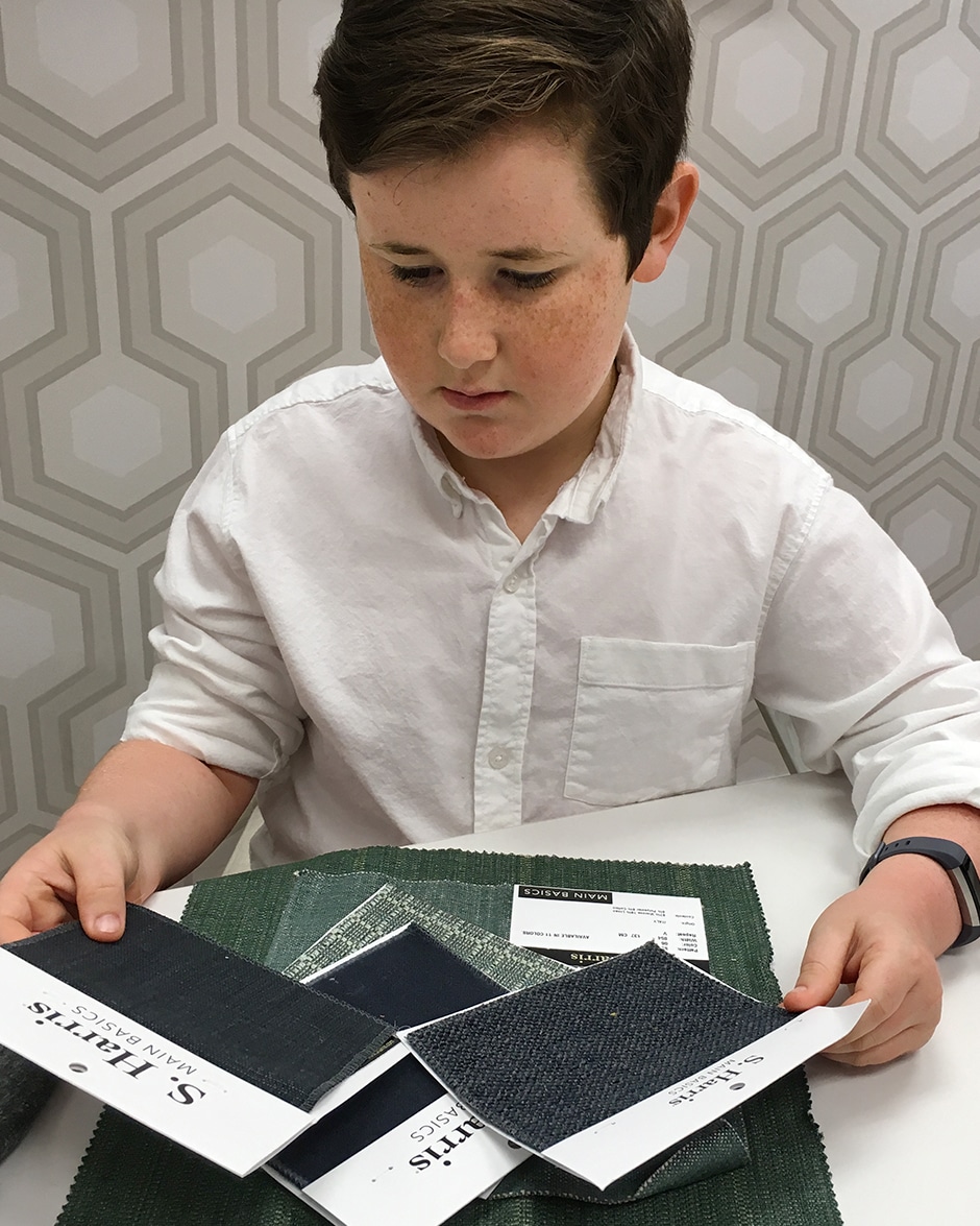 graham sitting at table looking at fabric swatches