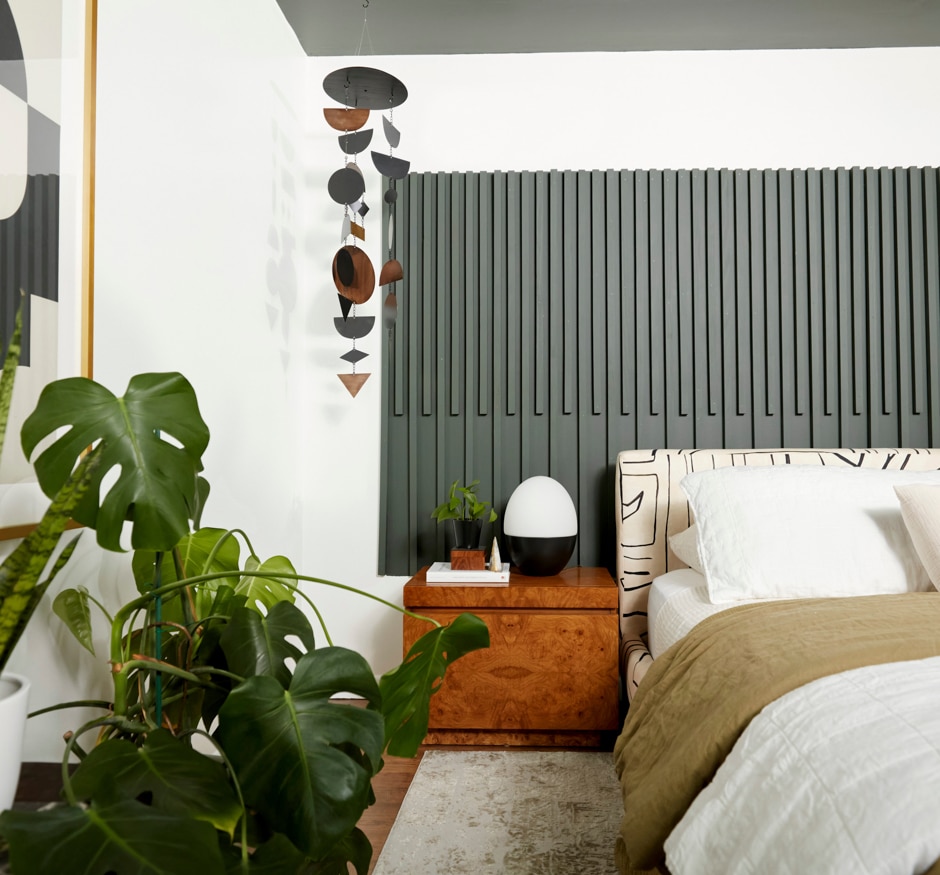 green, white, and black bedroom with graphic accents and plants