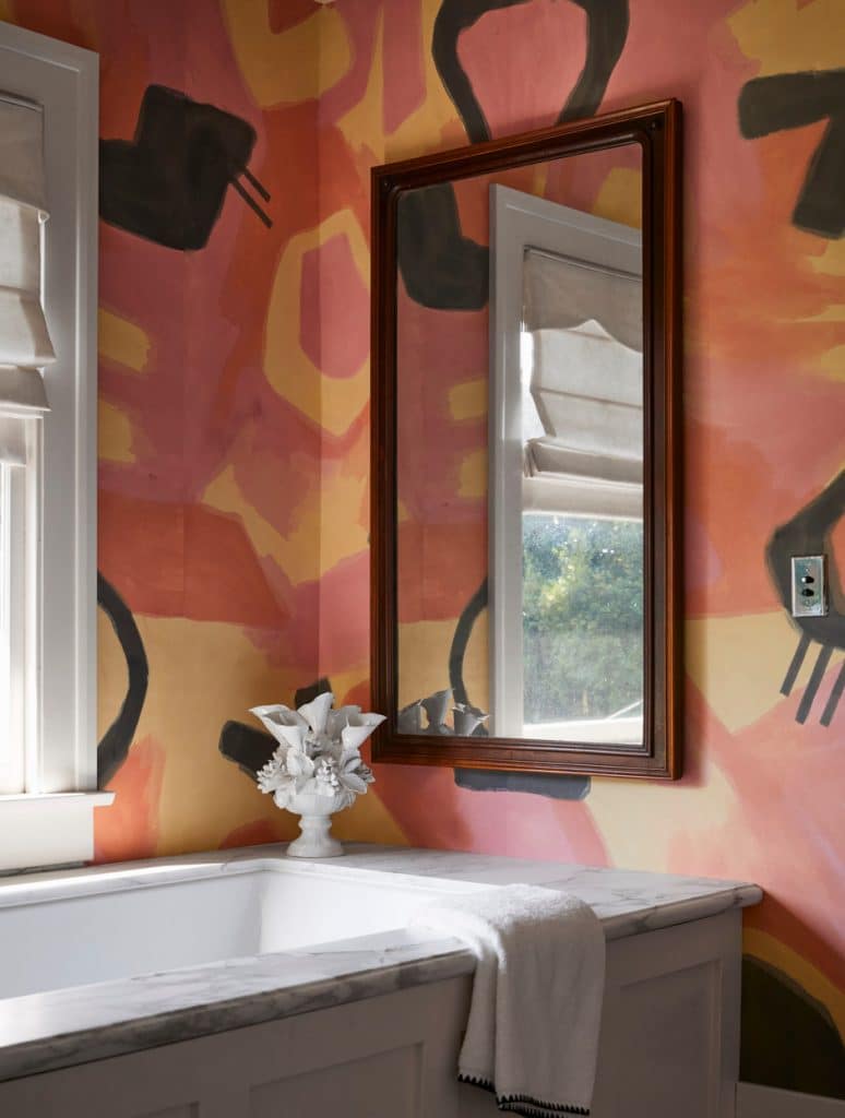 guest bathroom with watercolor painted wallpaper in graphic pink, orange, and black pattern