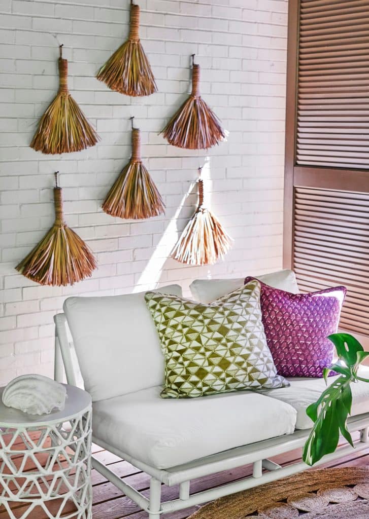 hand brooms hanging on porch as art installation