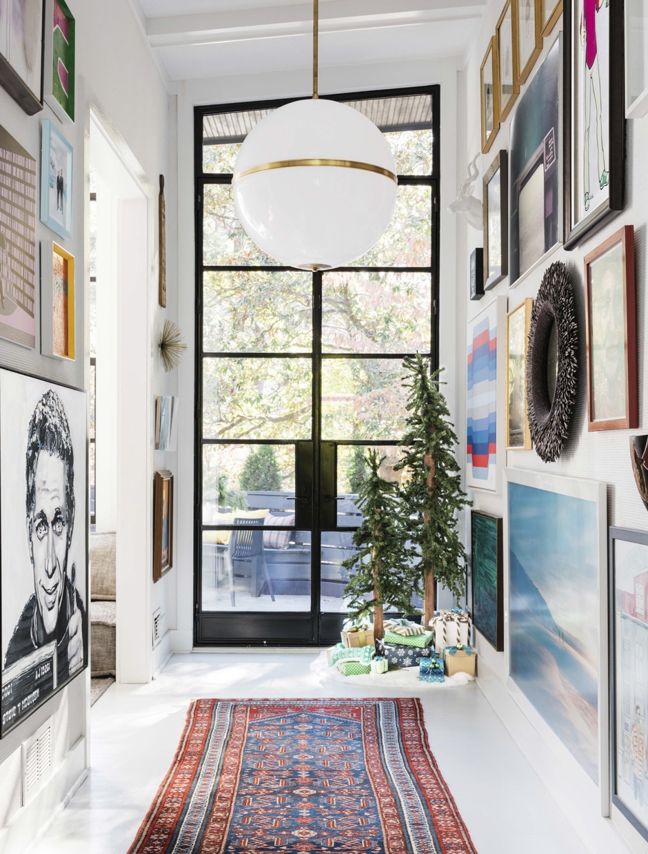 high ceiling hallway to patio doors with walls covered in artwork