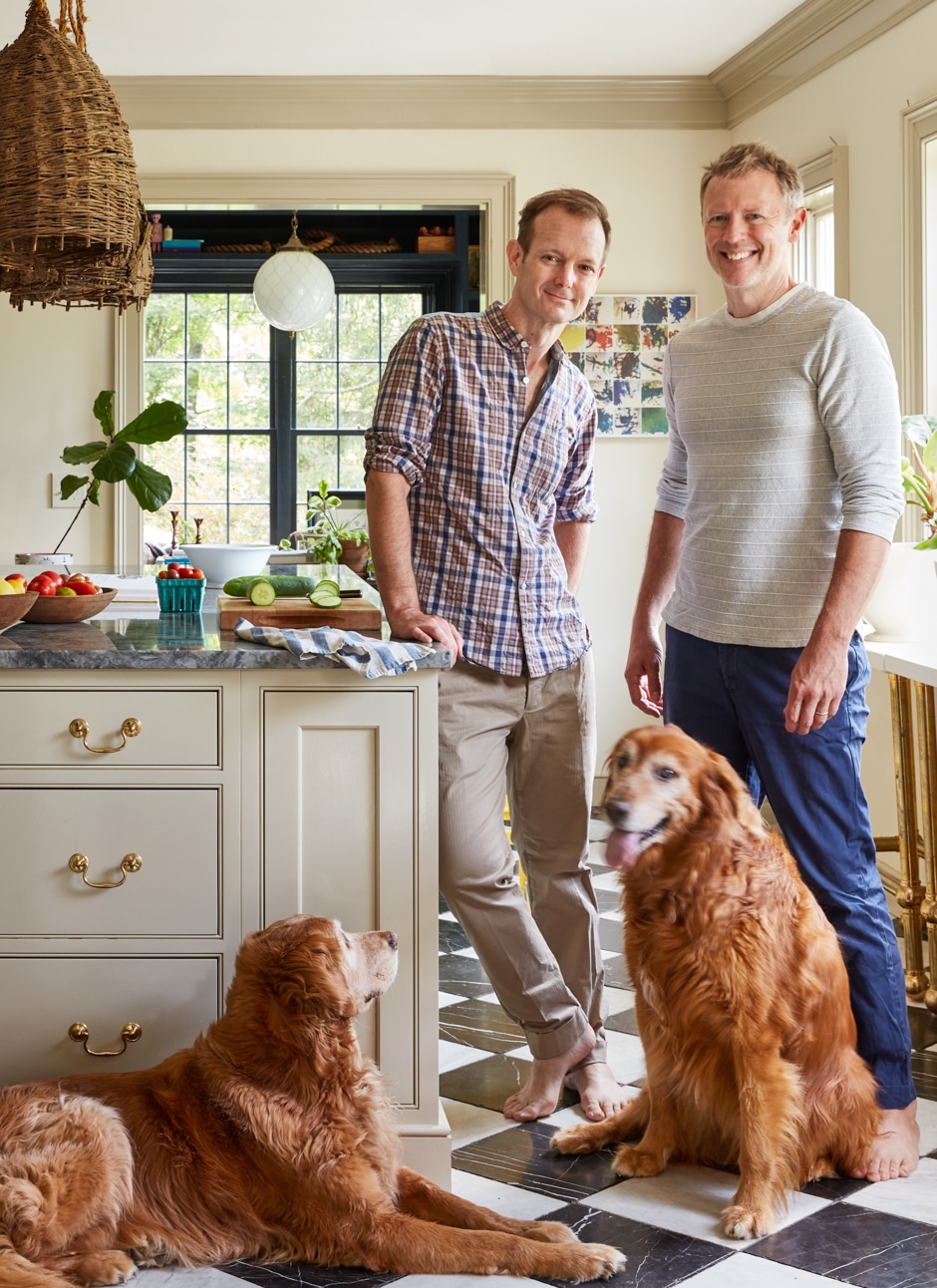 Joe and Dale standing in sunny kitchen with two golden retrievers