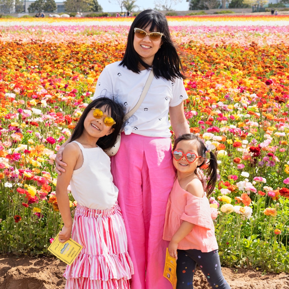 Joy with daughters in front of colorful flower field