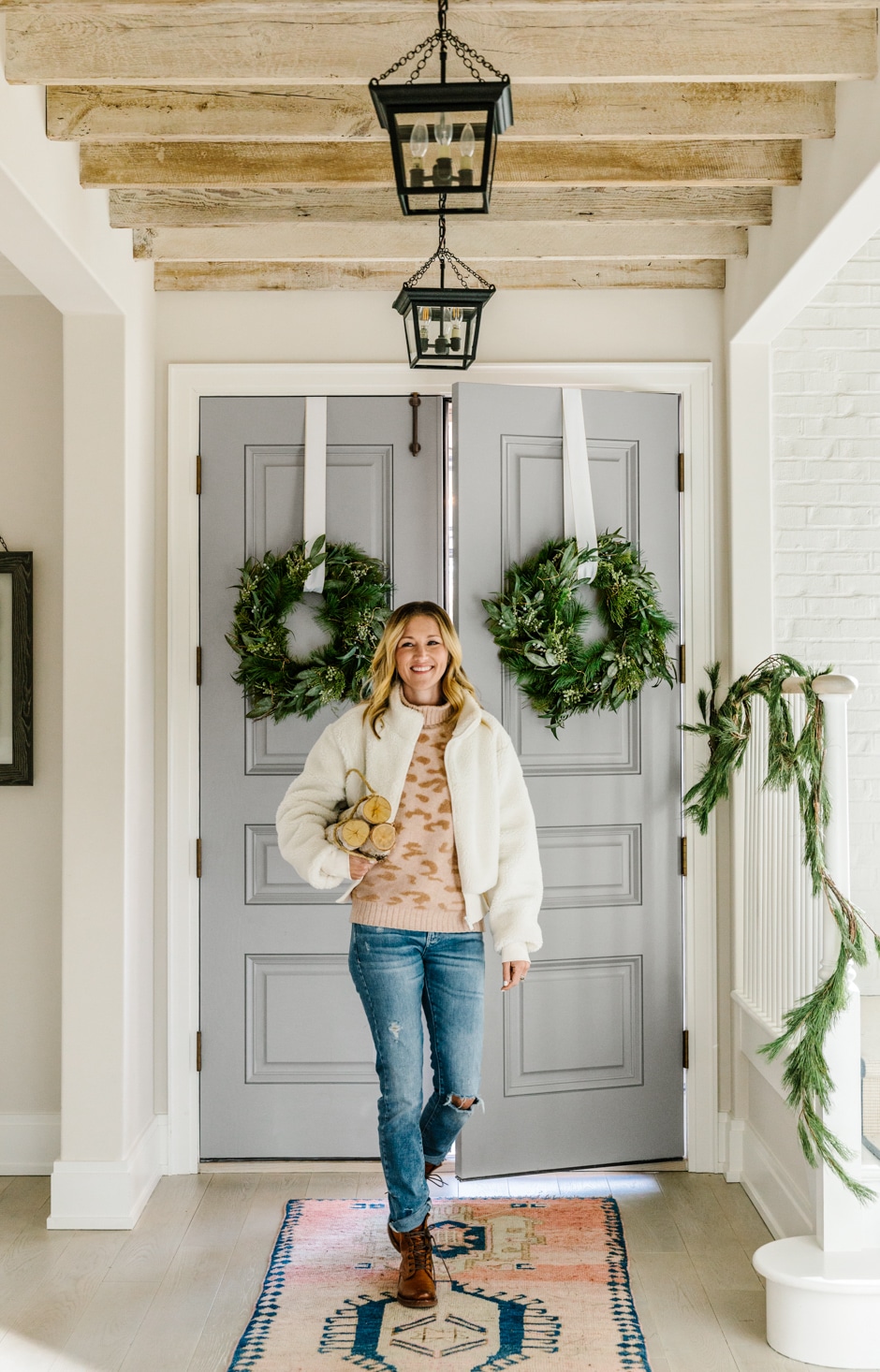 kate entering house through double door entrance with hanging wreaths