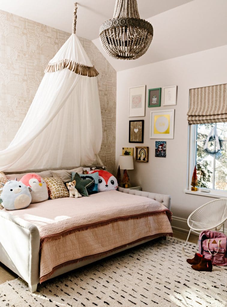 girls bedroom with canopy and patterned walls