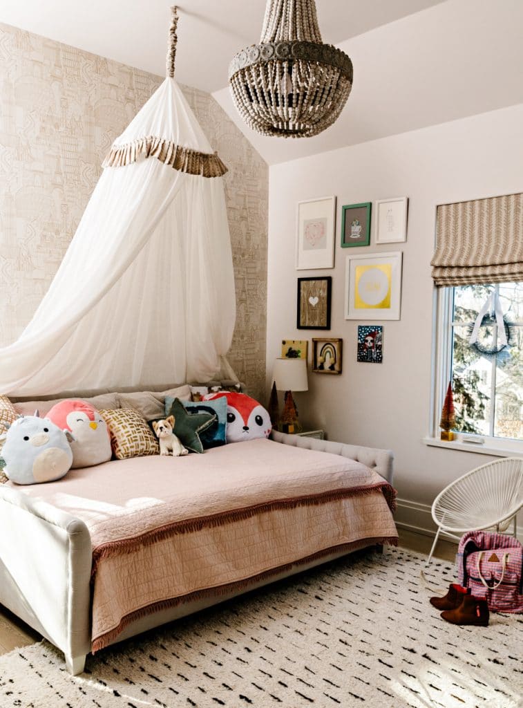 girls bedroom with canopy and patterned walls