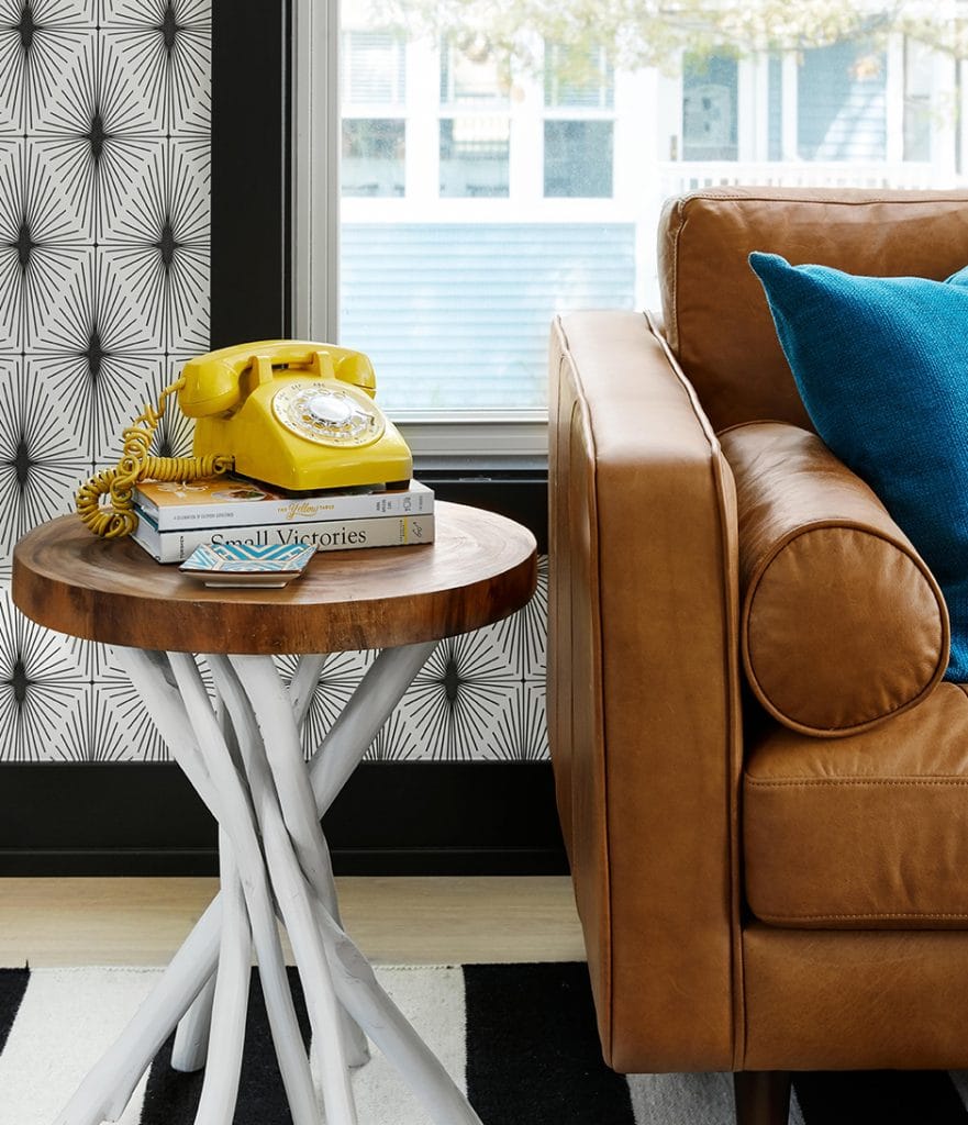 leather couch next to small table with yellow vintage phone