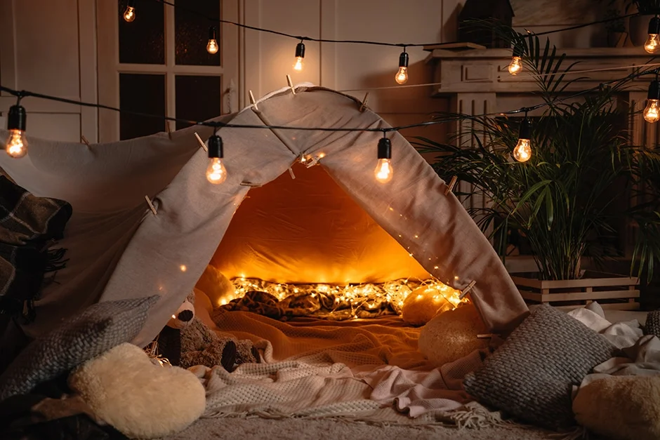 cozy tent in living room with string lights