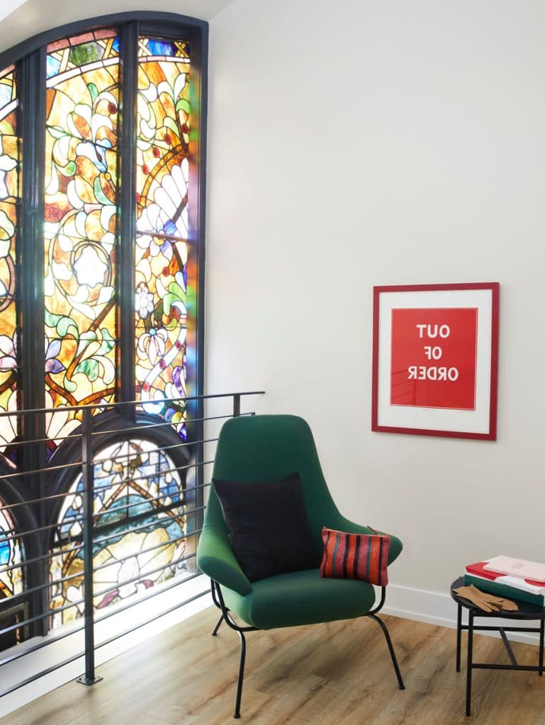 midcentury modern chair in front of stained glass window