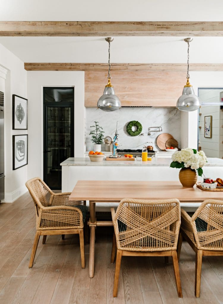 modern white kitchen with long wooden table and wicker chairs