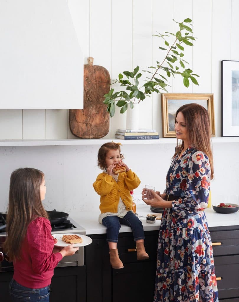mother and daughters eating waffles in kitchen