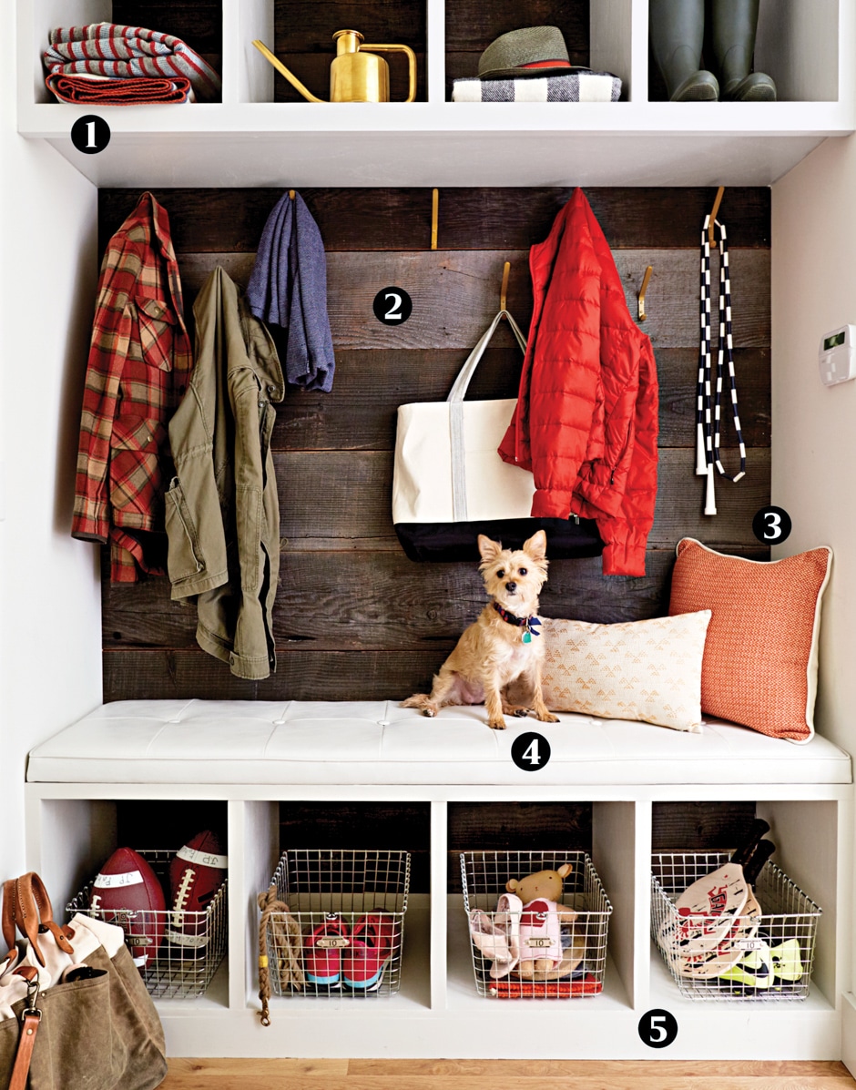 faux mudroom with white bench, wire baskets, hanging jackets, and little dog