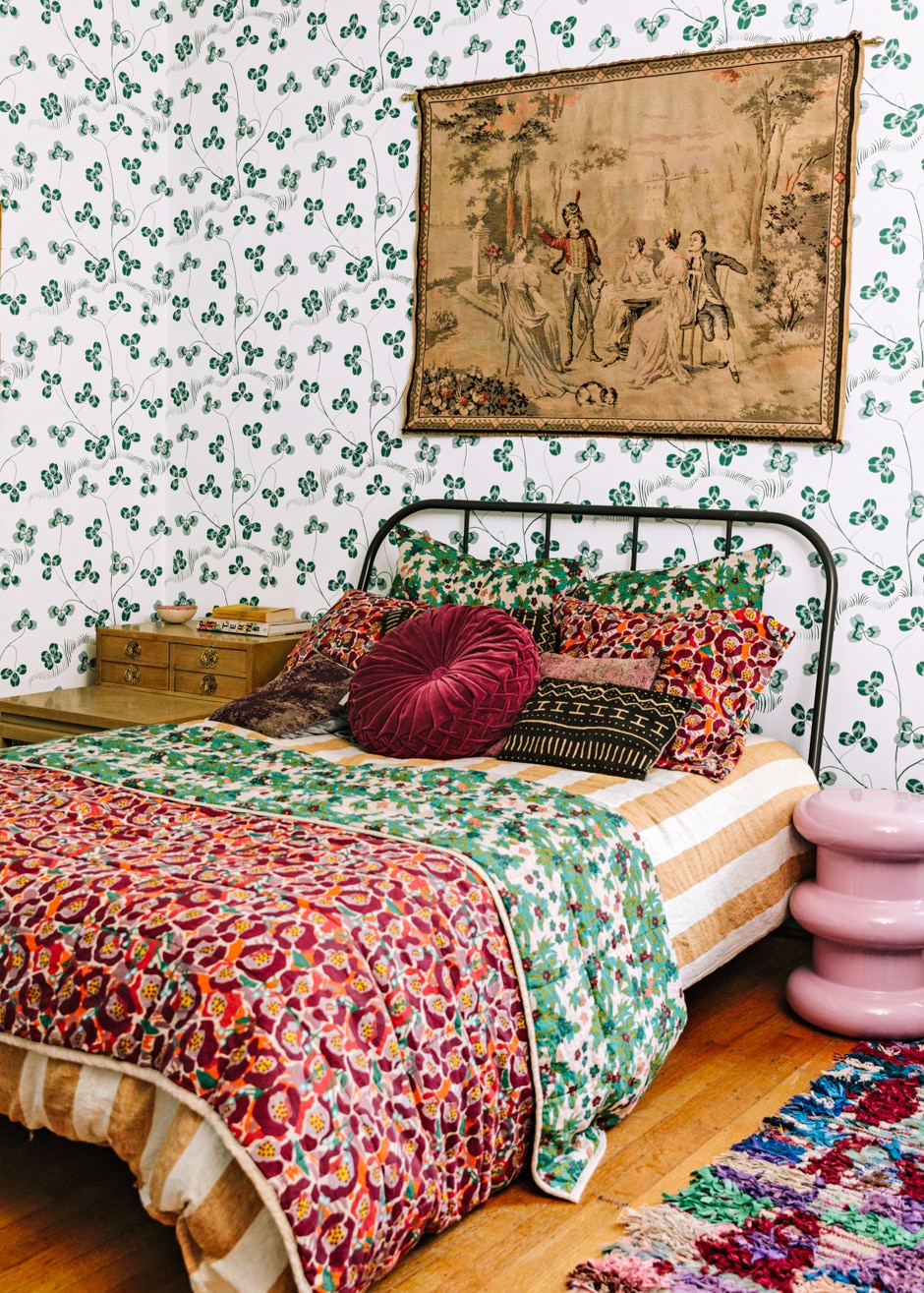 eclectic patterned guest bedroom with colorful pillows and wallpaper