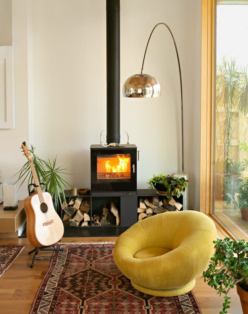 living room with stove, yellow chair and bohemian rugs