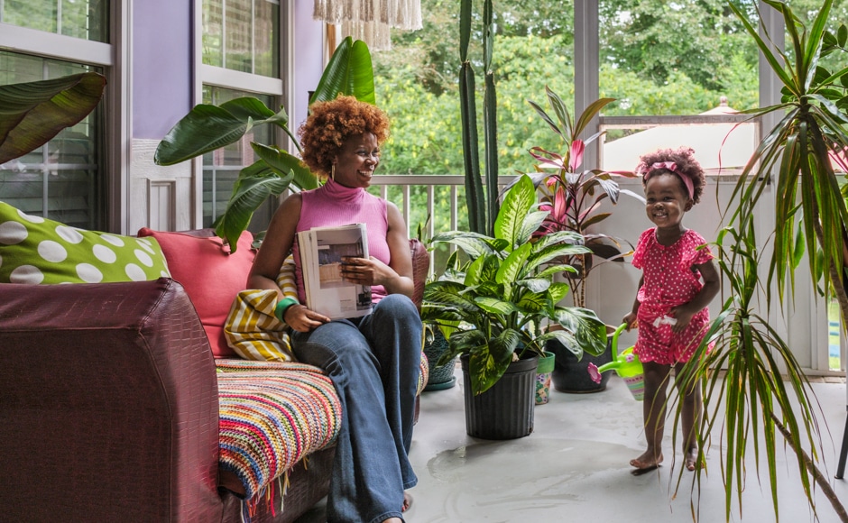 Stacey and daughter on porch filled with tropical plants