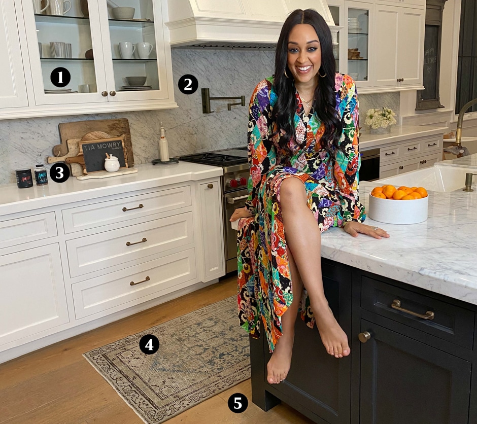 Tia Mowry sitting on kitchen island with numbers