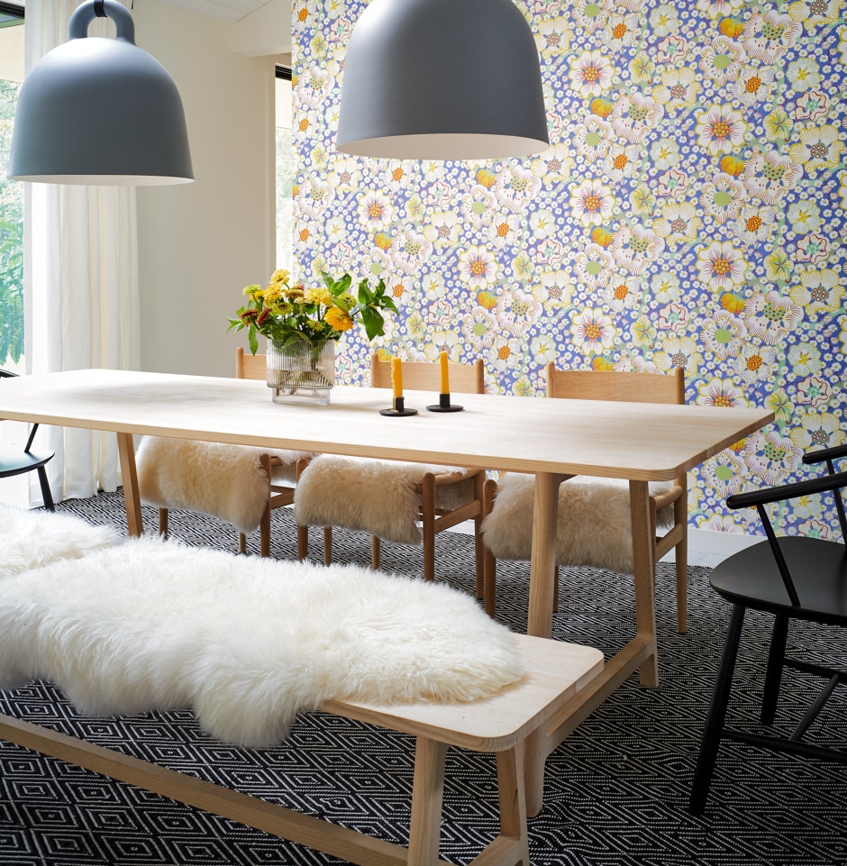 modern cozy swedish dining room with flowered wallpaper, wooden table and bench seats