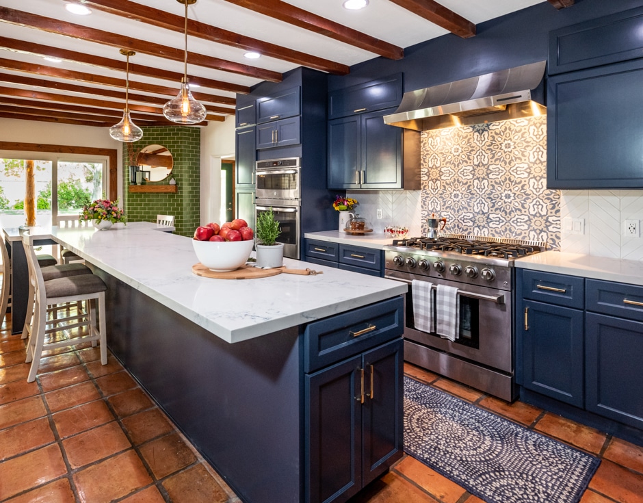 warm blue kitchen with green accents, stone floor, and wooden ceiling slats