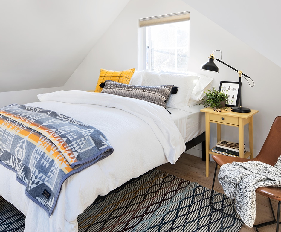 white simple bedroom with blue and yellow accents
