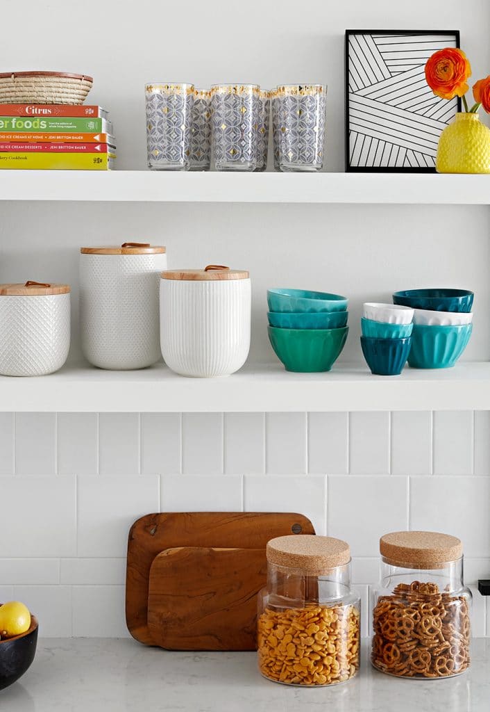 white kitchen shelves with colorful dishes and snacks