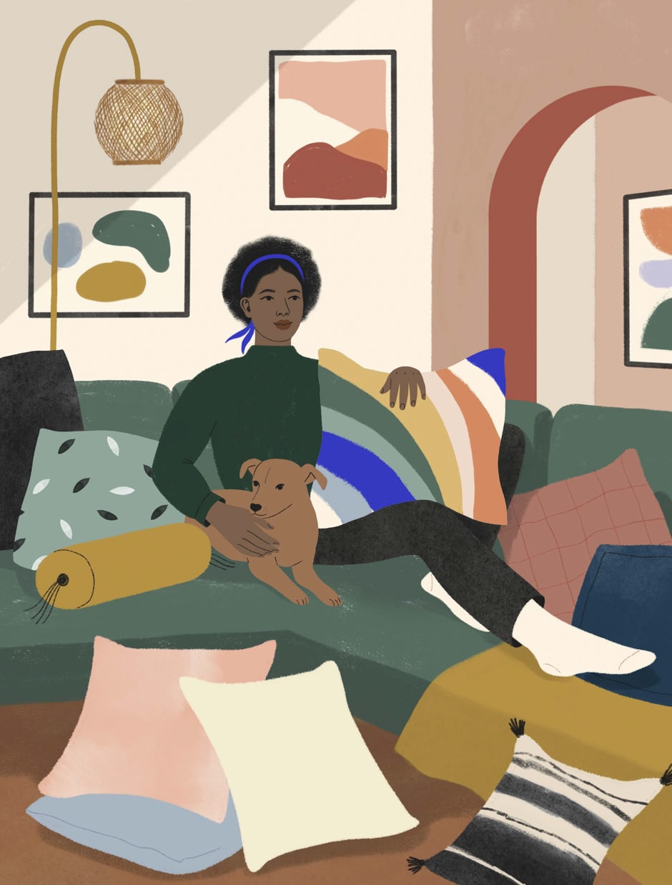woman sitting on couch with dog and pillows