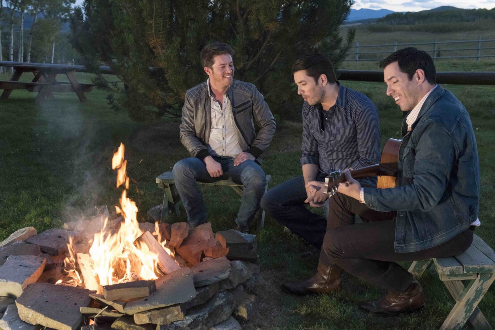 Drew, Jonathan, and JD sit around a backyard bonfire