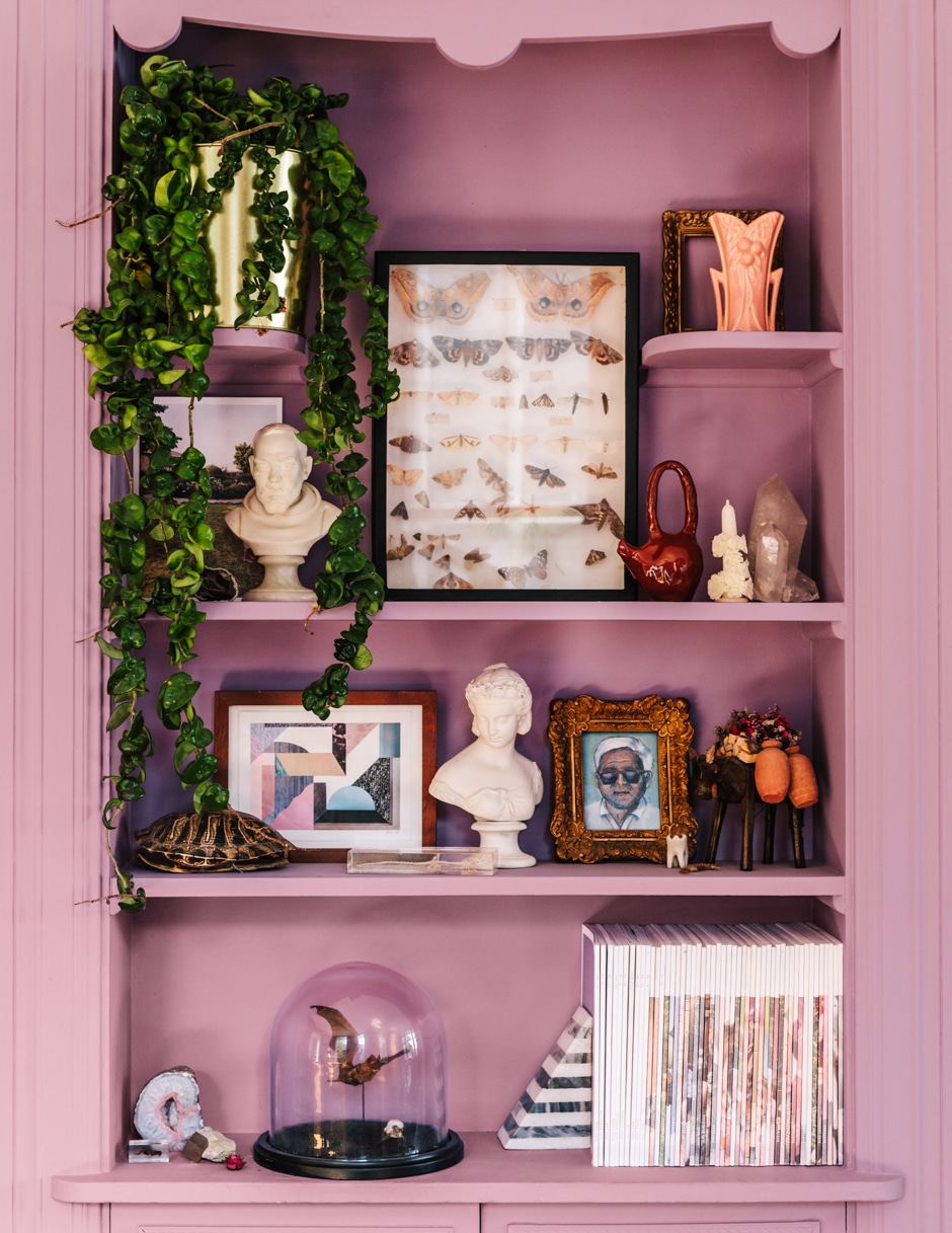 purple shelve with art, plants, and trinkets