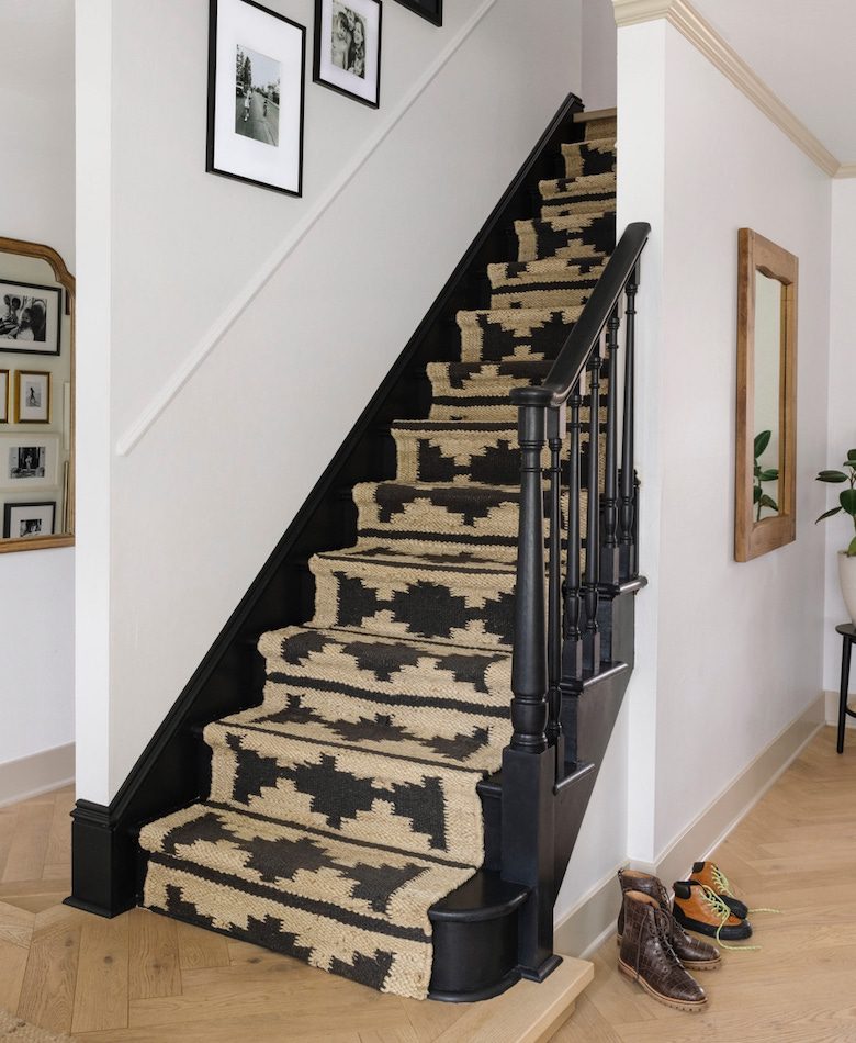 Black staircase with patterned natural stair runner
