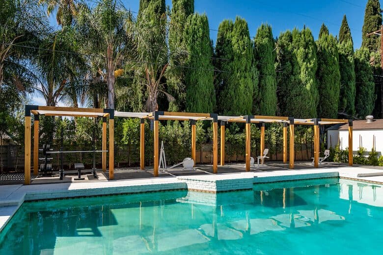 Pool with exercise equipment under cabanas