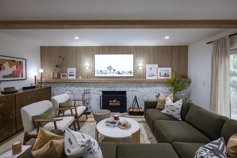 Living room with green couch and white chairs in jericka and matthew's episode of Property Brothers Forever Home
