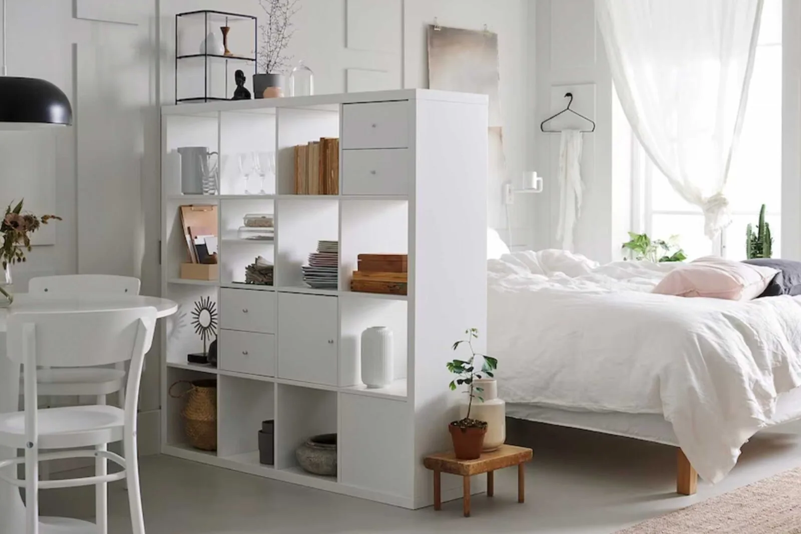 Minimalistic bedroom with a bookshelf divider and cozy bed