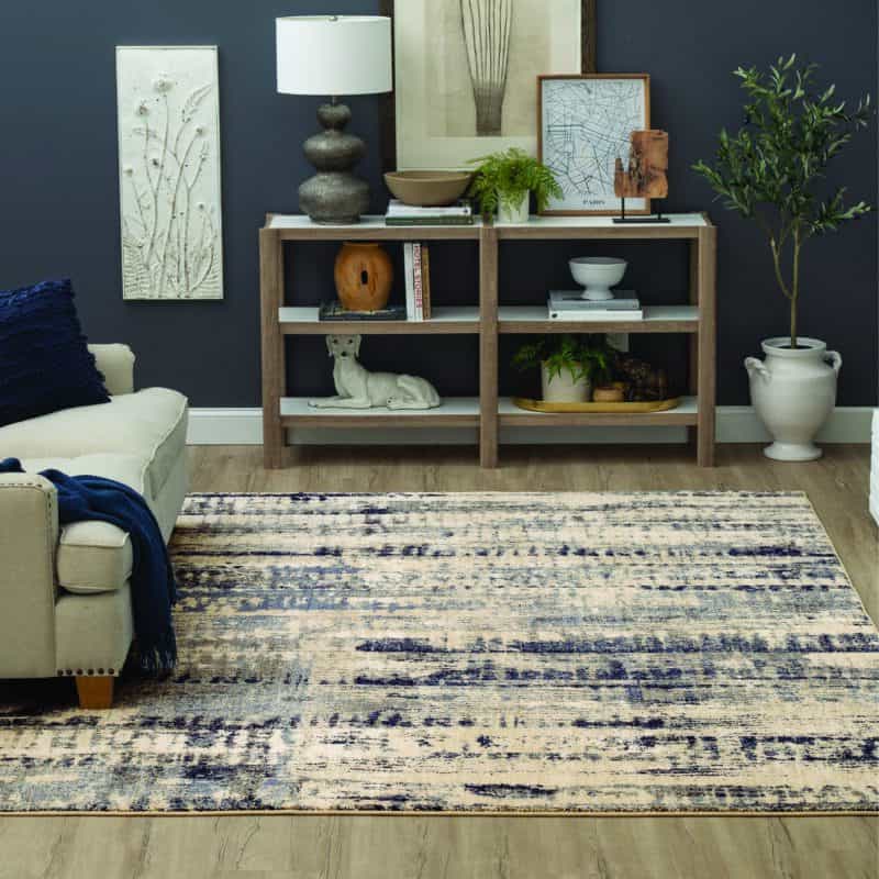 Stylish living room with abstract area rug, modern decor, and wooden bookshelf