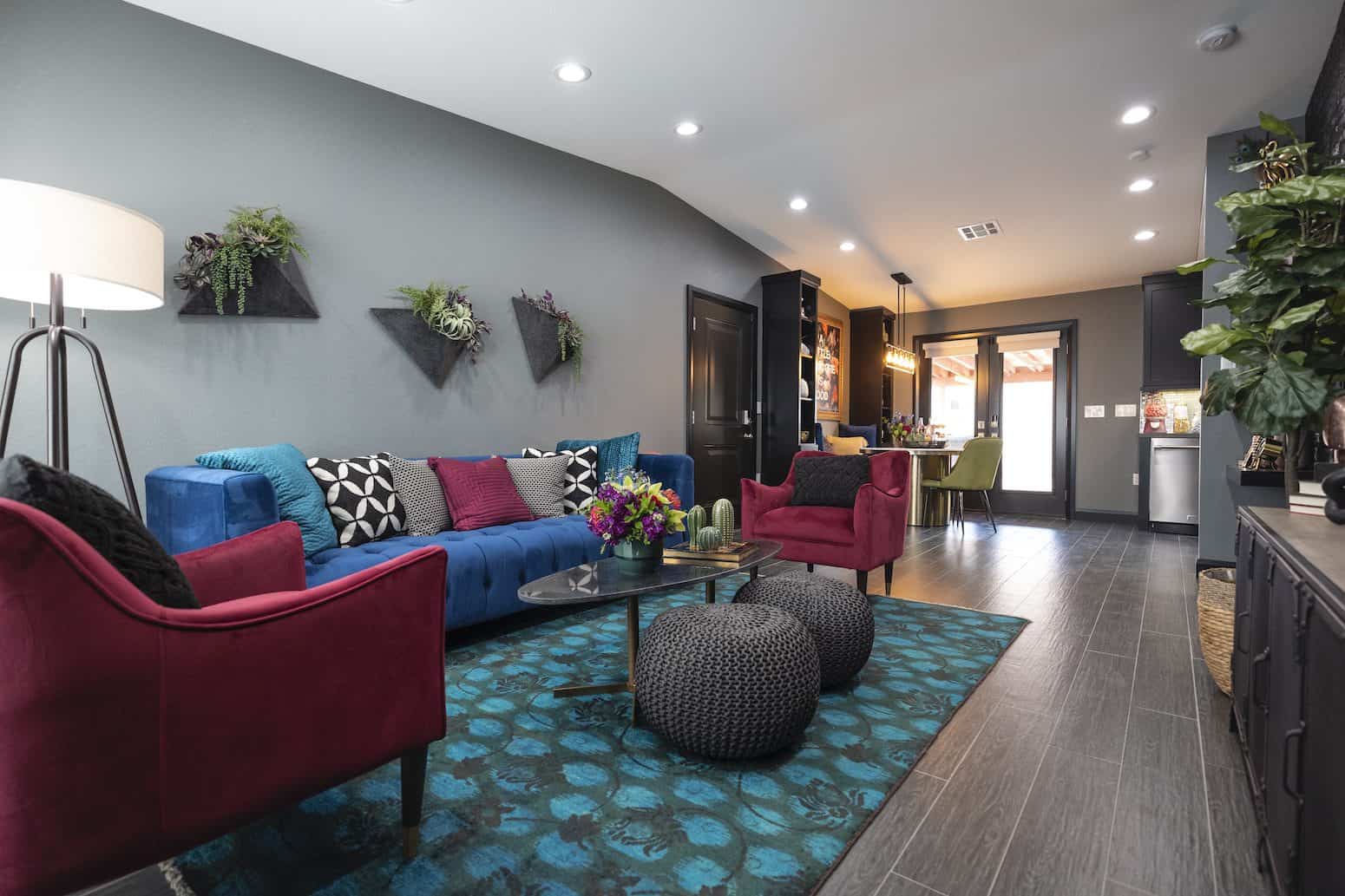 Living room with a blue sofa, purple armchairs, and wall plants