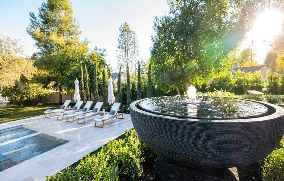 Outdoor setting with a water fountain and swimming pool