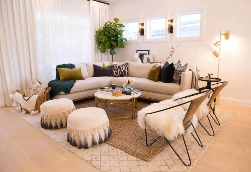 Bright and inviting living space featuring a curved sofa, layered textiles, cozy seating, and natural accents