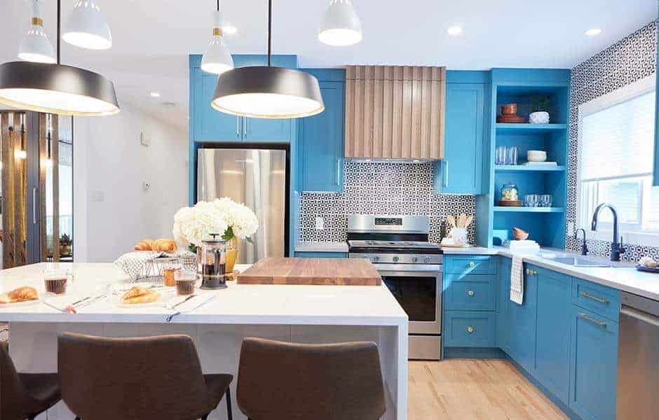 Bright kitchen with blue cabinets, patterned backsplash, and a large island