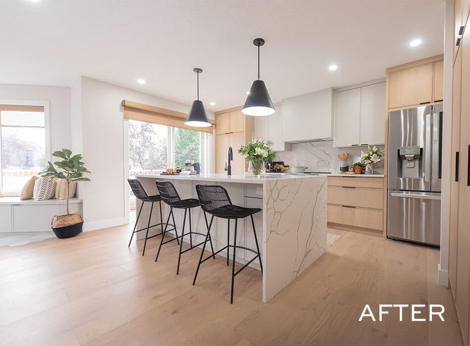 Kitchen with a marble island, black barstools, and pendant lighting